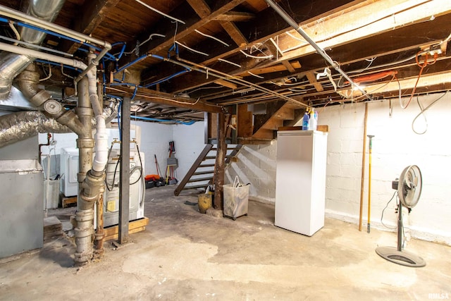 basement with white fridge and washer / dryer