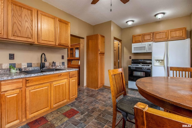 kitchen with a textured ceiling, ceiling fan, white appliances, and sink