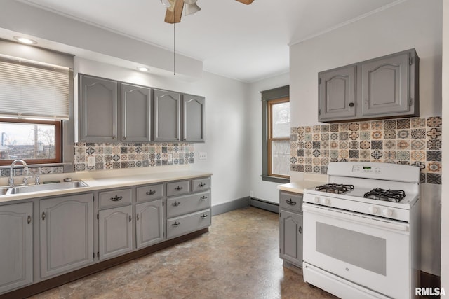 kitchen with decorative backsplash, ceiling fan, white gas range, and sink