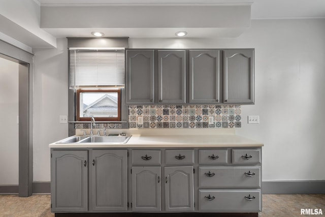 kitchen with decorative backsplash, gray cabinetry, and sink