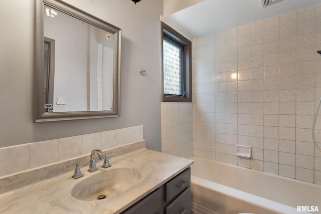 bathroom featuring vanity and tiled shower / bath