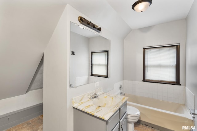 bathroom with vanity, a tub to relax in, toilet, and lofted ceiling