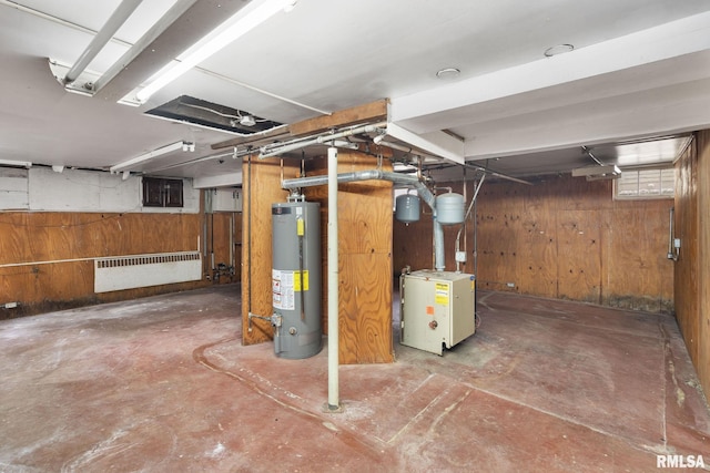 basement featuring gas water heater and wooden walls