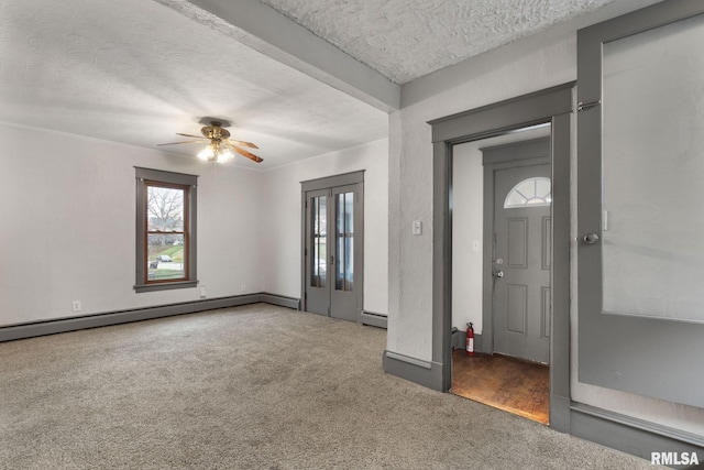 carpeted entrance foyer with ceiling fan, baseboard heating, and a textured ceiling