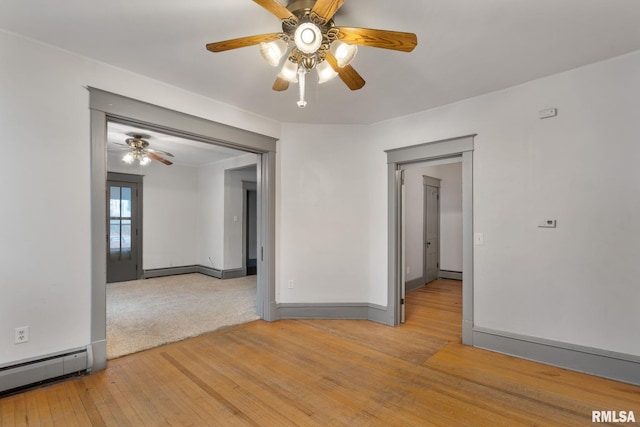 empty room featuring light wood-type flooring, a baseboard radiator, and ceiling fan