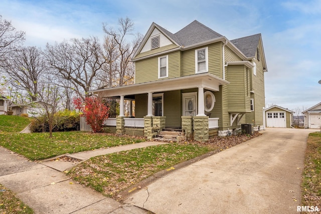 view of front of house with a front yard, a porch, central AC, a garage, and an outdoor structure