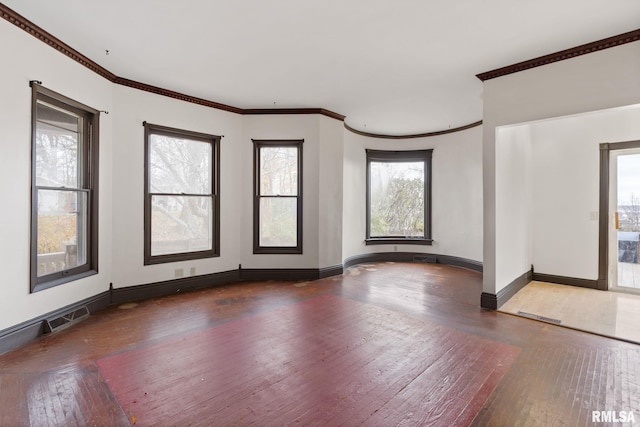 spare room with hardwood / wood-style floors, a healthy amount of sunlight, and ornamental molding