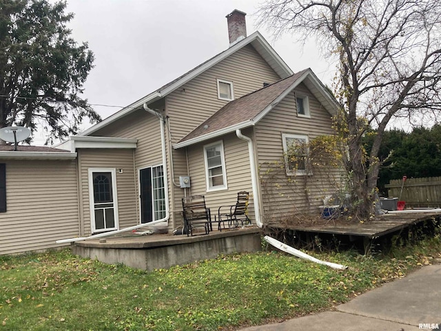 rear view of property with a lawn and a deck