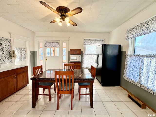 dining space featuring light tile patterned floors, visible vents, and a ceiling fan