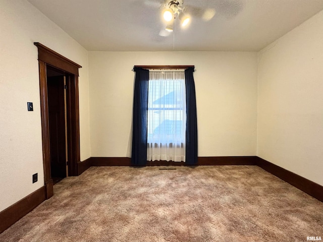 spare room featuring carpet and baseboards