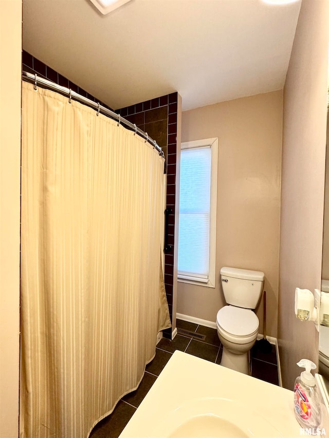 bathroom with a shower with curtain, baseboards, toilet, and tile patterned floors