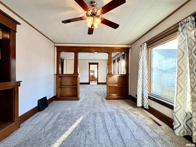 empty room featuring crown molding, visible vents, light carpet, ceiling fan, and baseboards