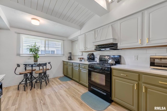 kitchen featuring white cabinets, decorative backsplash, light hardwood / wood-style floors, and black gas stove