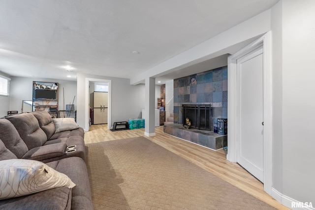 living room with a fireplace and light wood-type flooring