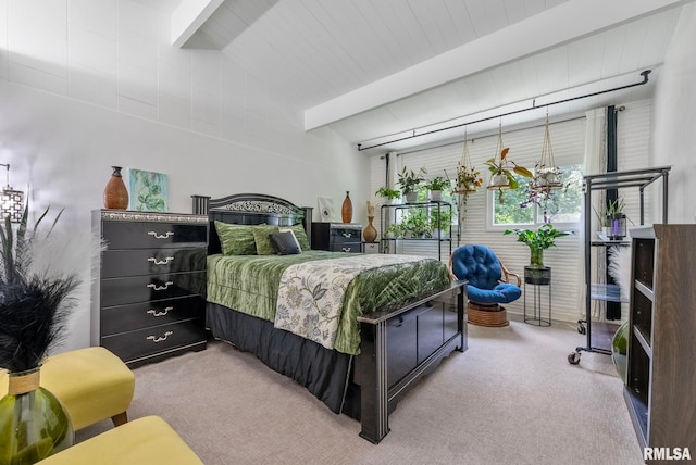 bedroom with beamed ceiling and light colored carpet