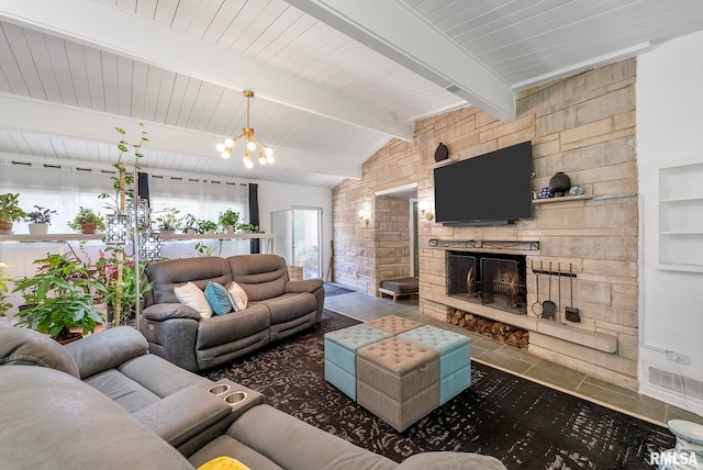 living room featuring a chandelier, lofted ceiling with beams, and a stone fireplace