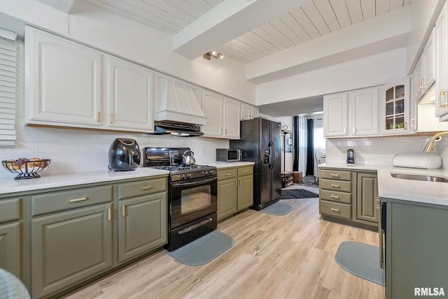 kitchen featuring white cabinetry, sink, light hardwood / wood-style flooring, black appliances, and custom range hood