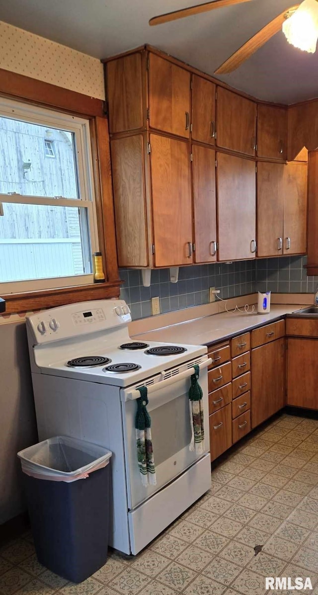 kitchen with tasteful backsplash, white electric stove, and sink