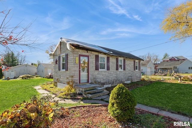 bungalow featuring stone siding and a front yard