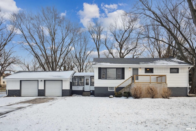 view of front of house featuring a garage, a wooden deck, and a sunroom