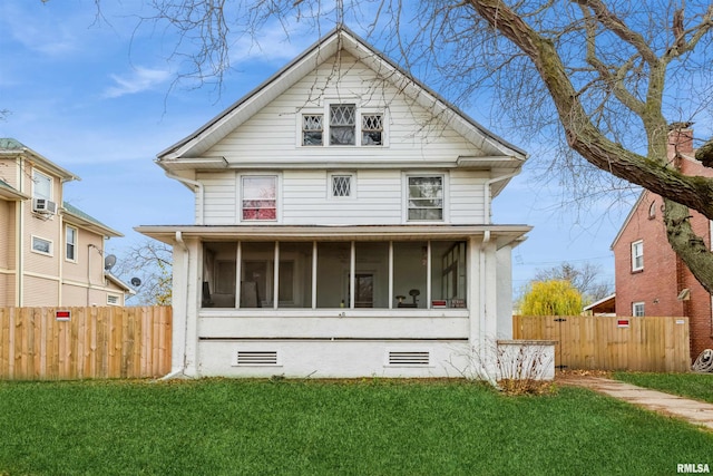 rear view of house featuring a sunroom and a yard