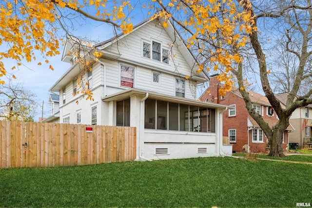 view of front facade with a sunroom and a front yard