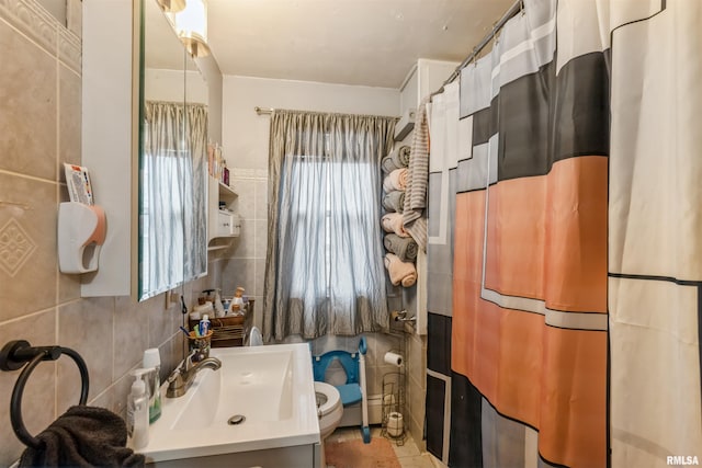 bathroom with vanity, tile patterned floors, toilet, tile walls, and walk in shower