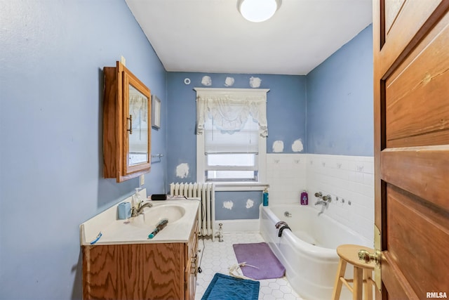 bathroom with vanity, radiator heating unit, and a bath