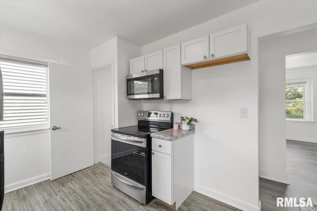 kitchen featuring white cabinetry, appliances with stainless steel finishes, and light hardwood / wood-style flooring