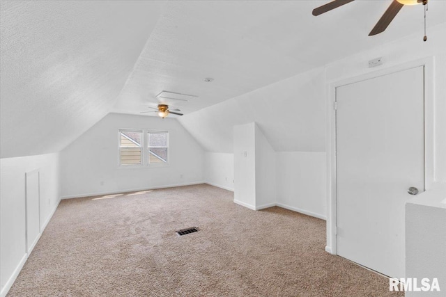 bonus room with a textured ceiling, ceiling fan, light carpet, and vaulted ceiling