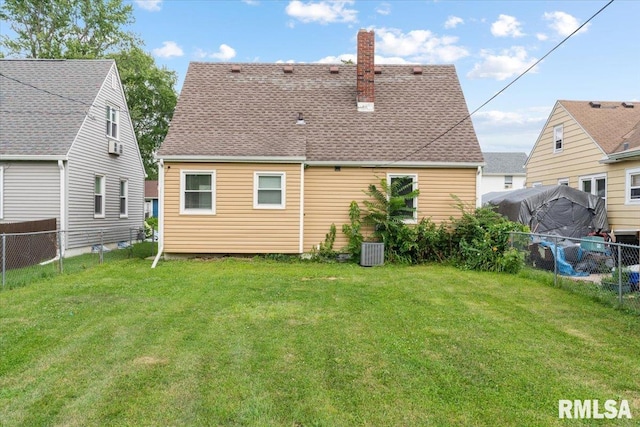 back of property with a yard and central air condition unit