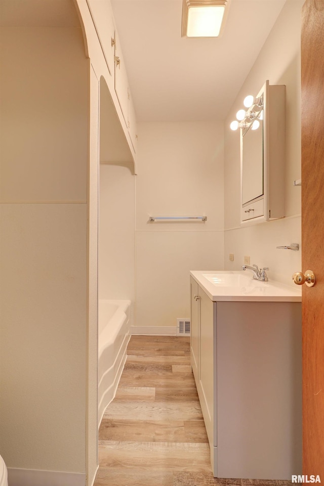 bathroom featuring hardwood / wood-style floors, vanity, and a bathtub