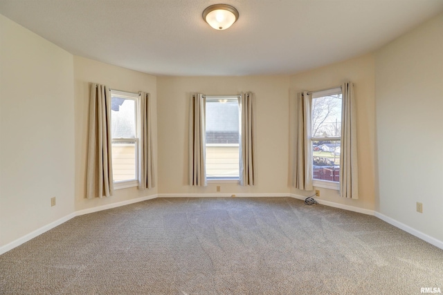 carpeted spare room featuring plenty of natural light