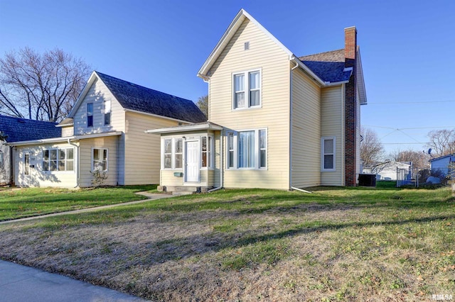 view of front of property with a sunroom and a front yard