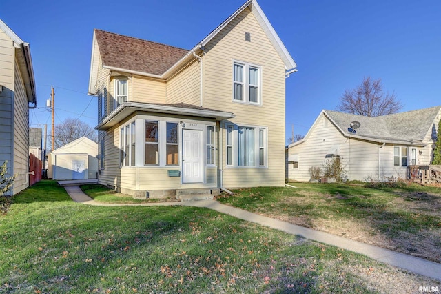 view of front of house with a garage, a front lawn, and an outdoor structure