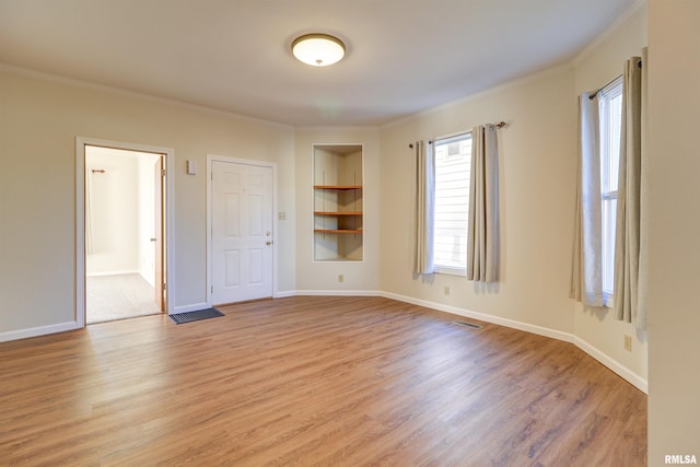 empty room with light hardwood / wood-style flooring and ornamental molding