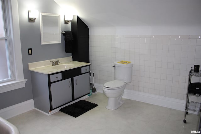 bathroom featuring vanity, tile walls, and toilet