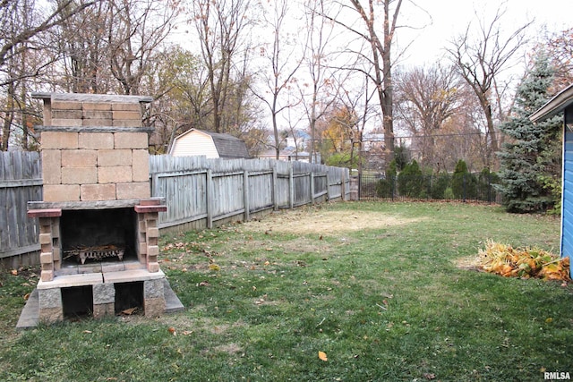 view of yard with an outdoor stone fireplace