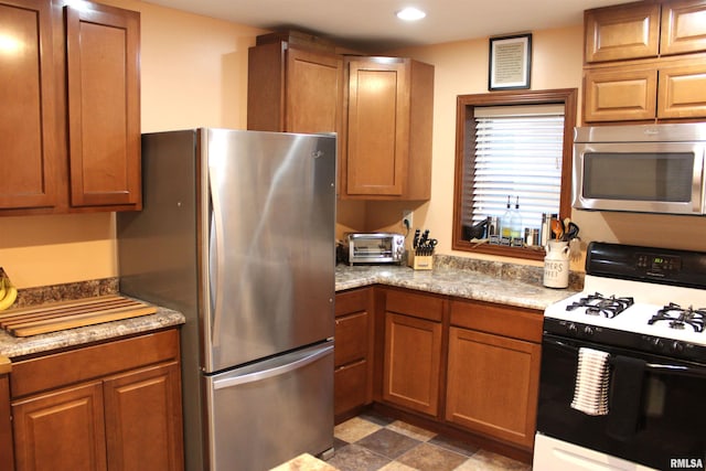 kitchen featuring appliances with stainless steel finishes and light stone counters