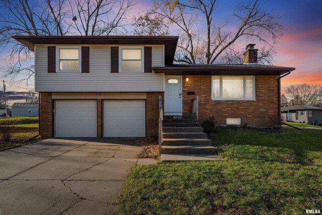 tri-level home featuring a yard and a garage