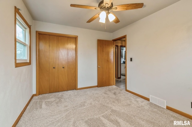 unfurnished bedroom featuring carpet, a closet, and ceiling fan