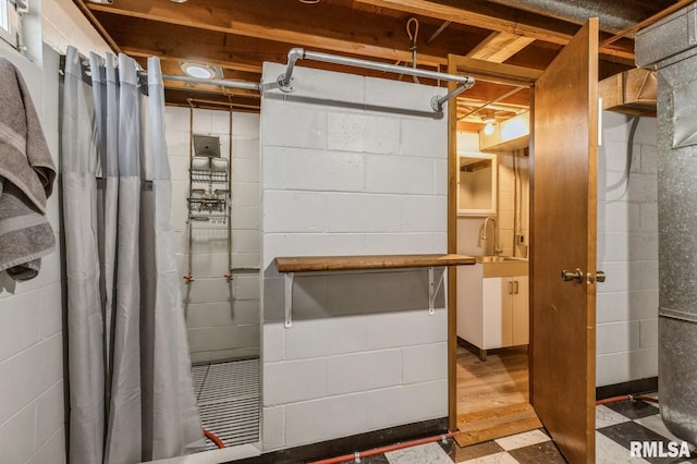 basement with sink and hardwood / wood-style flooring