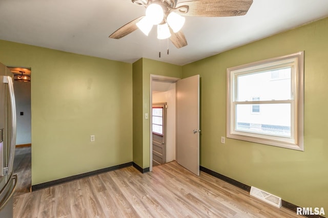 unfurnished bedroom with ceiling fan, light hardwood / wood-style floors, and stainless steel refrigerator with ice dispenser