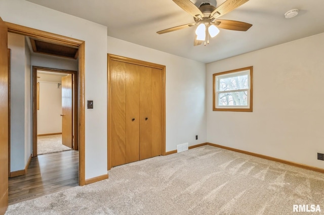 unfurnished bedroom with ceiling fan, carpet floors, and a closet