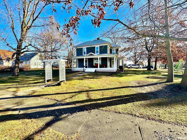 view of front of property featuring a sunroom and a front lawn