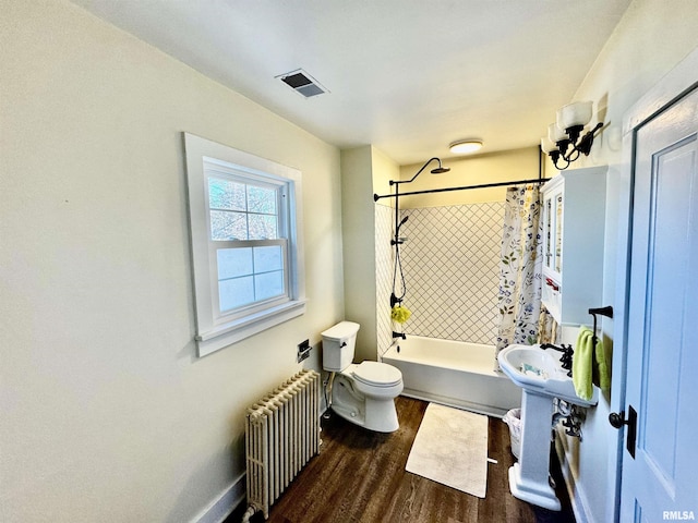 bathroom with hardwood / wood-style flooring, toilet, radiator, and shower / tub combo with curtain