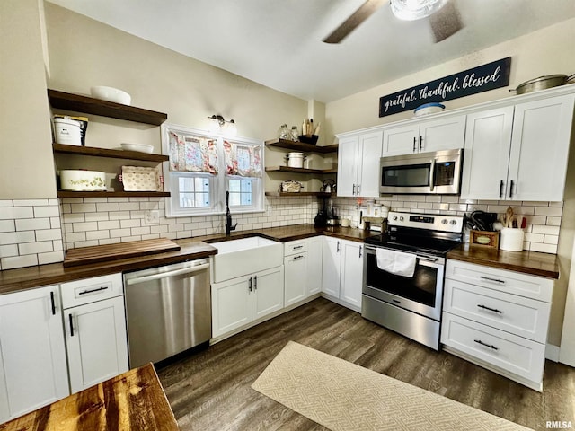 kitchen with dark hardwood / wood-style flooring, tasteful backsplash, stainless steel appliances, sink, and white cabinets