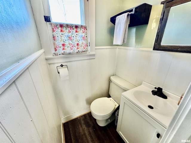 bathroom featuring hardwood / wood-style floors, vanity, toilet, and wood walls