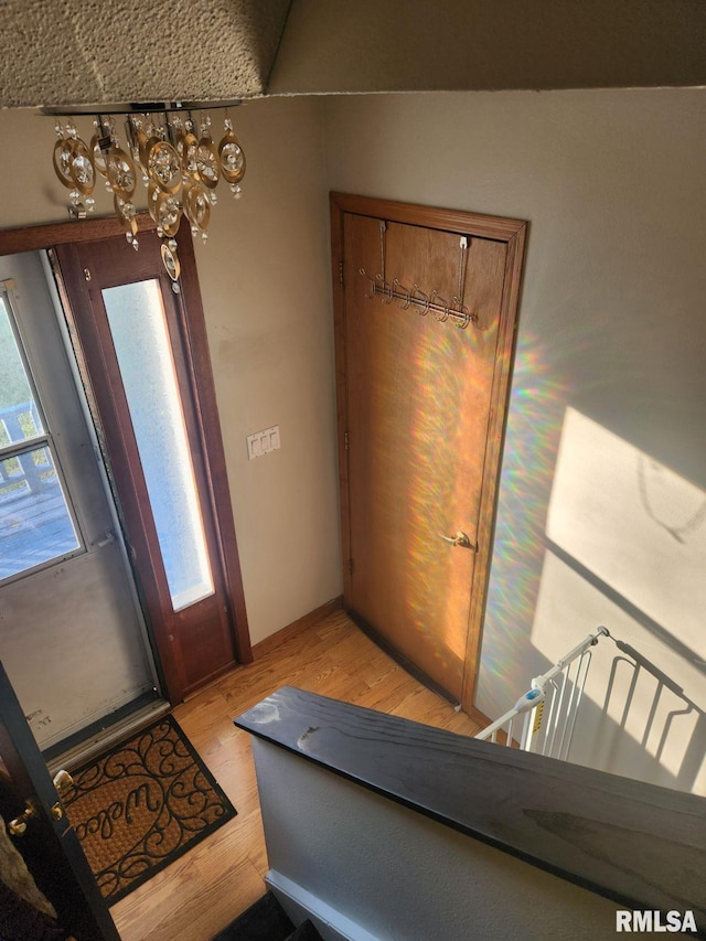 entryway featuring light hardwood / wood-style floors, a wealth of natural light, and an inviting chandelier