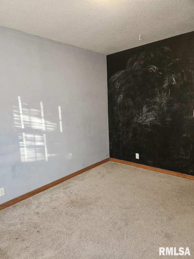 carpeted spare room with a textured ceiling